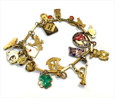 Lot 2469 - A 14ct gold bracelet hung with charms of...