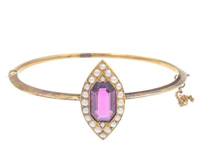 Lot 36 - An antique gold, garnet, and seed pearl bangle bracelet.