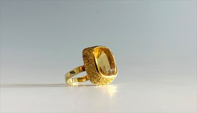 Lot 2500 - A 14ct gold ring set a citrine in a textured...