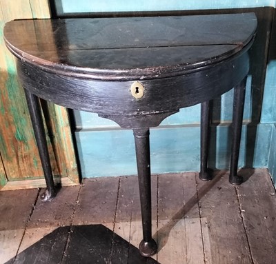 Lot 75 - A George II oak fold top half round tea table.
