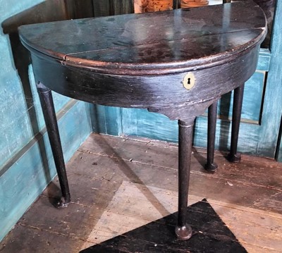Lot 75 - A George II oak fold top half round tea table.