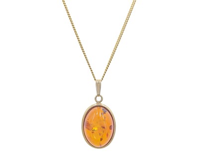 Lot 48 - A 9k gold, amber set pendant on 9k gold curb chain.