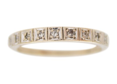 Lot 55 - An 18k white gold and diamond half-eternity band ring.