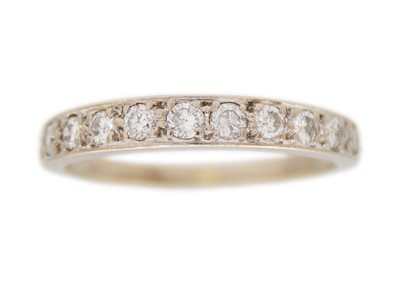 Lot 59 - An 18k white gold and diamond graduated half-eternity band ring.