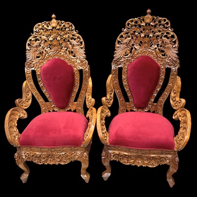 Lot 89 - A pair of highly carved Indonesian armchairs,...