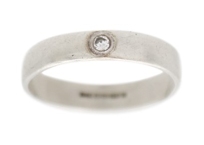 Lot 123 - A 9k white gold and diamond band ring.