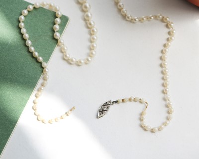 Lot 192 - A cultured pearl necklace with a gold and diamond clasp.