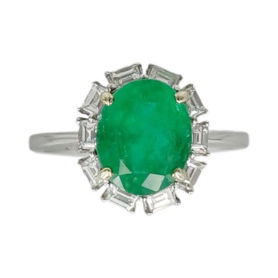 Lot 163 - An 18k white gold, emerald, and diamond cluster ring.