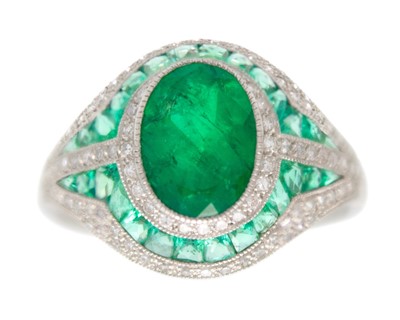 Lot An Art Deco-style emerald and diamond dress ring set in platinum.