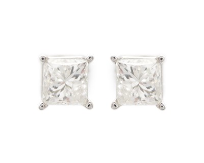 Lot 72 - A pair of 14k white gold and diamond solitaire stud earrings.