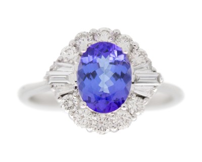 Lot 81 - An 18k white gold, tanzanite, and diamond cluster ring.