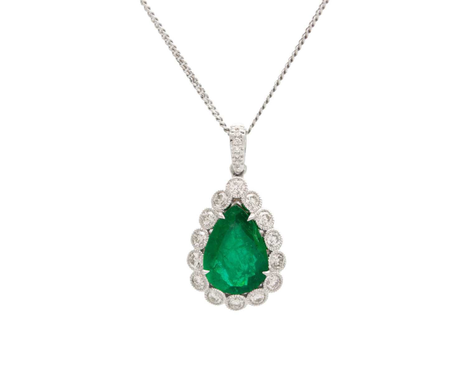 Lot 90 - An 18k two-tone gold, emerald, and diamond pendant on a silver necklace.