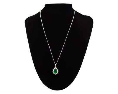 Lot 90 - An 18k two-tone gold, emerald, and diamond pendant on a silver necklace.