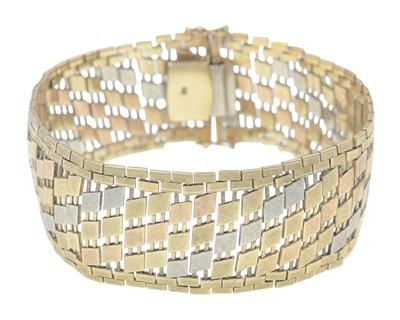 Lot 80 - A stylish and heavy 9k tri-colour gold fancy link wide band bracelet.