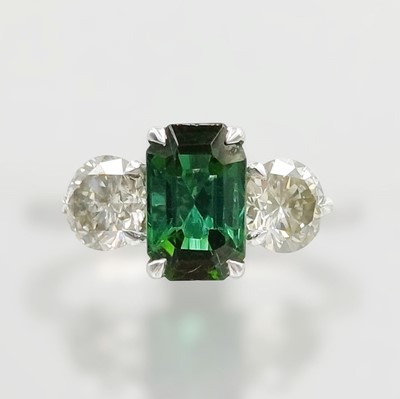 Lot 145 - A three-stone green tourmaline and diamond ring in platinum.
