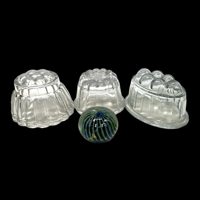 Lot 142 - Three glass jelly moulds and a glass paperweight.