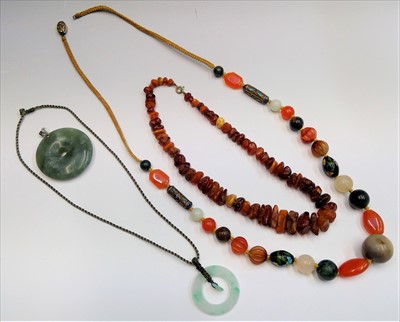 Lot 2622 - Two Chinese jade bi pendants, an amber...