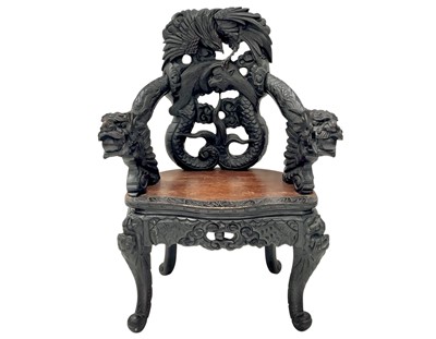 Lot 579 - An ornate Chinese export black lacquered elbow chair.
