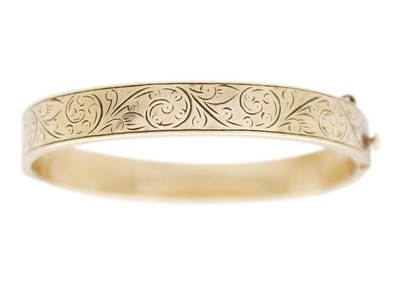 Lot 128 - A 9k gold metal core hinged bangle bracelet.