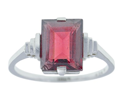 Lot 135 - An 18k white gold and garnet ring.