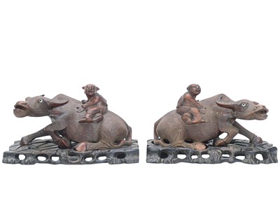 Lot 535 - A pair of Chinese hardwood figures of boys on buffalo.