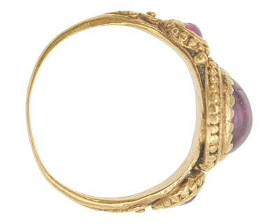 Lot 155 - An Antique Etruscan style granulated gold three-stone pink sapphire and tourmaline set ring.