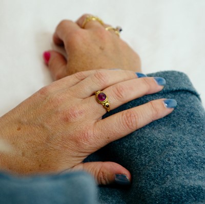 Lot 155 - An Antique Etruscan style granulated gold three-stone pink sapphire and tourmaline set ring.
