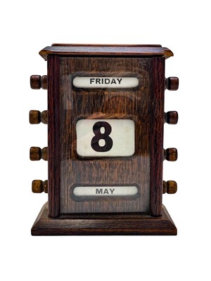 Lot 160 - An early 20th century stained oak perpetual desk calendar.