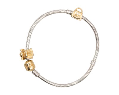Lot 129 - PANDORA - A 14k and silver charm bracelet.