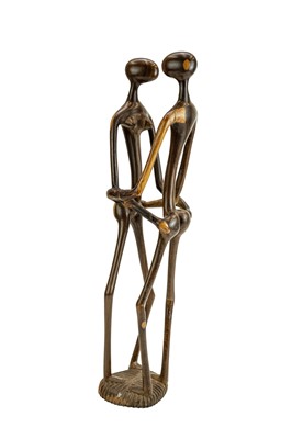 Lot 34 - An East African carved ebony or lignum vitae figure group.