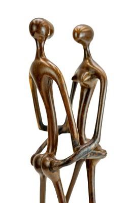 Lot 34 - An East African carved ebony or lignum vitae figure group.