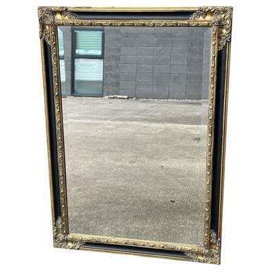 Lot 113 - An Ornate Black and Gilt finish bevel edge...