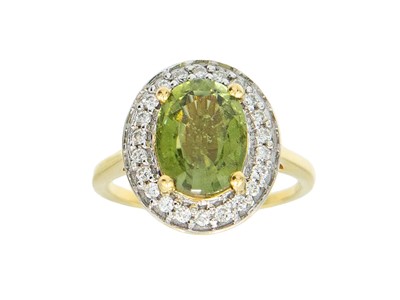 Lot 67 - LORIQUE - An olive tourmaline and diamond 18k gold ring.