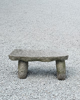 Lot 755 - A rough hewn granite garden bench of rustic design with curved seat.
