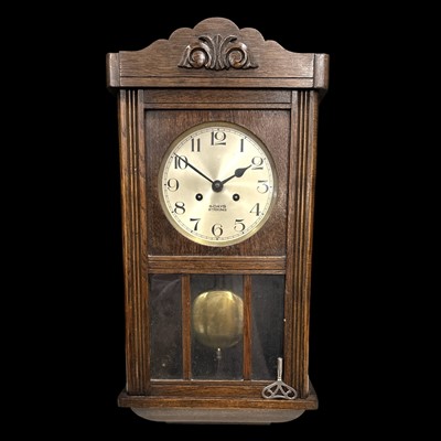 Lot 121 - An oak 8-day chiming wall clock, 63cm long.