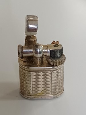 Lot 10 - DUNHILL - A 'Baby Sylph' silver-plated engine turned miniature lighter.
