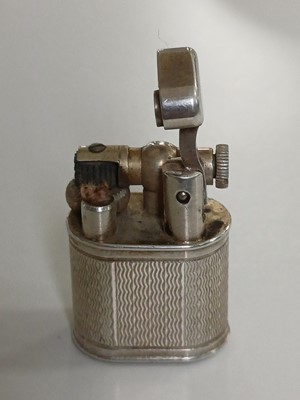 Lot 10 - DUNHILL - A 'Baby Sylph' silver-plated engine turned miniature lighter.