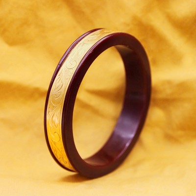 Lot 30 - A traditional Indian 22k gold bangle on a resin frame.