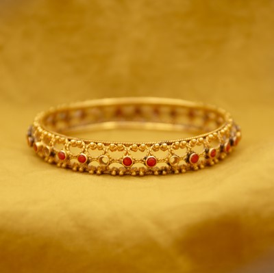 Lot 41 - A traditional Indian 22k gold coral set bangle.