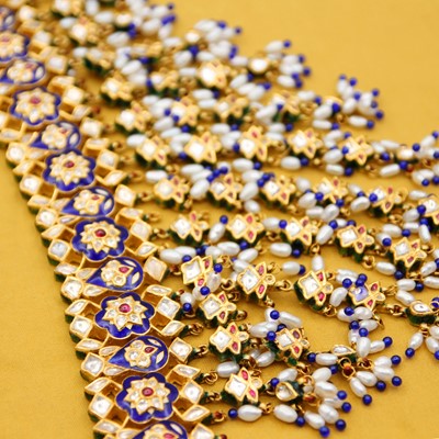 Lot 34 - A traditional Indian 22k gold, blue enamel, white sapphire, ruby, and pearl graduated fringe choker.