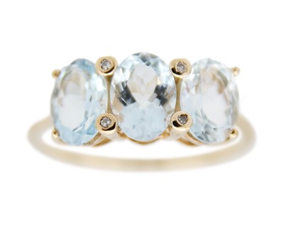 Lot 65 - A 9k gold three-stone aquamarine ring.