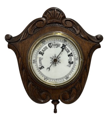 Lot 164 - A carved oak aneroid barometer, circa 1900,...
