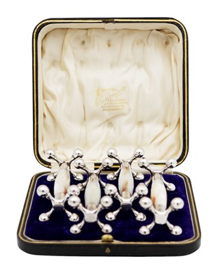 Lot 261 - An Edwardian boxed set of quality silver mounted mother of pearl knife rests.