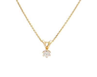 Lot 57 - A 14k gold diamond solitaire pendant on a gold-plated chain.