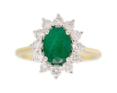 Lot 120 - An 18k gold emerald and diamond cluster ring.