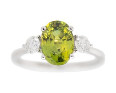 Lot 142 - An 18k white gold green sapphire and diamond ring.