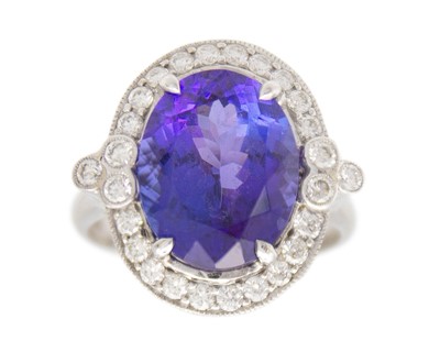 Lot 150 - An attractive 18k white gold tanzanite and diamond halo dress ring.