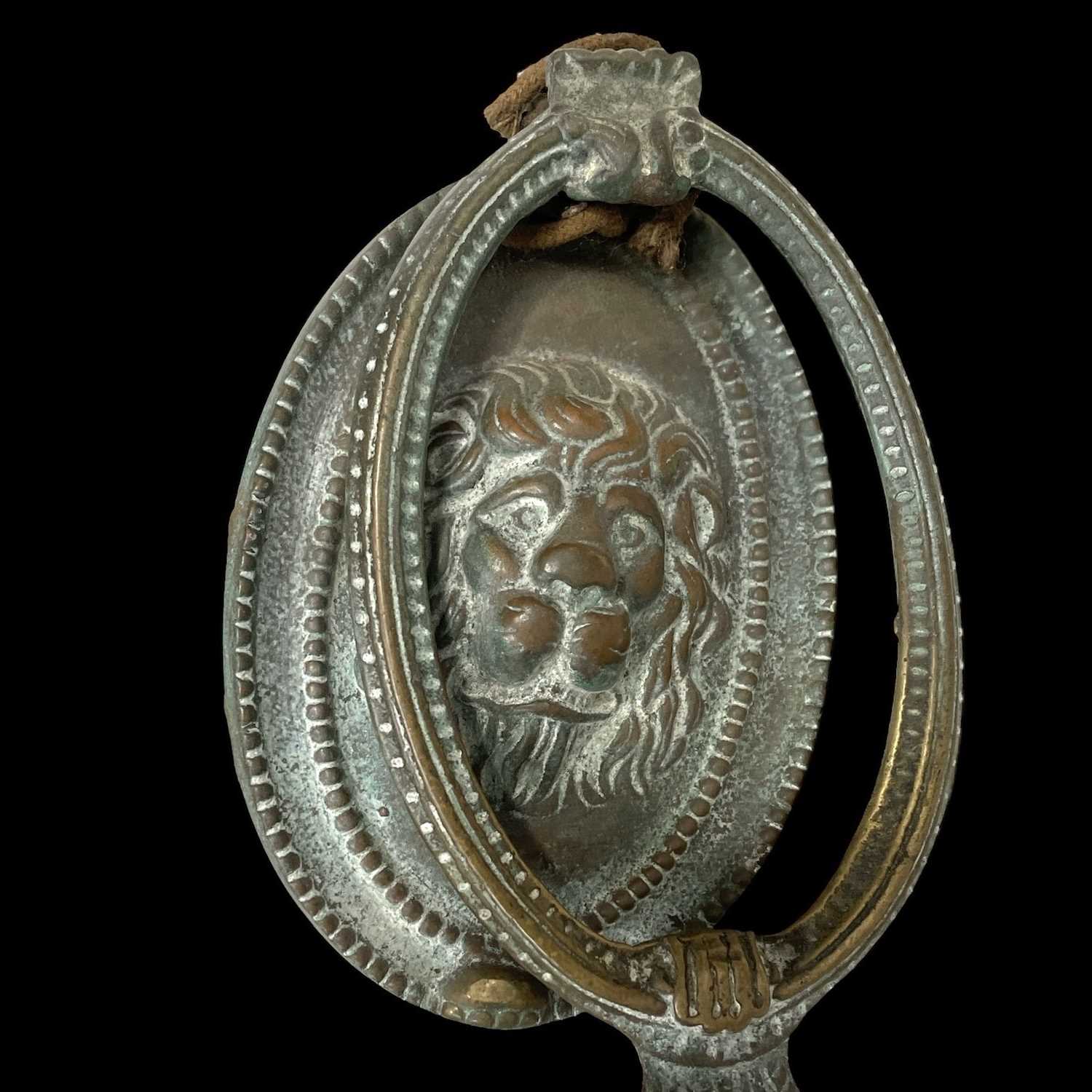Lot 150 - An antique brass lion's head door knocker,