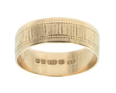 Lot 62 - A 9k hallmarked gold wide band ring with engraved decoration.