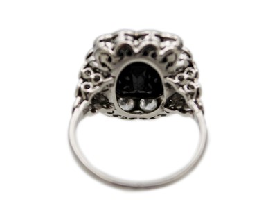 Lot 11 - An Art Deco style black onyx and diamond dress ring set in white gold.